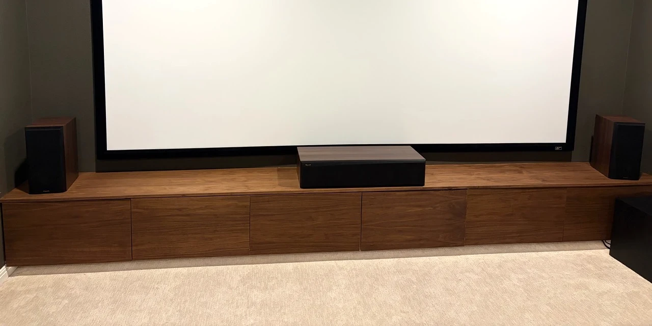 Floating wood media cabinetry beneath a home theater projection screen