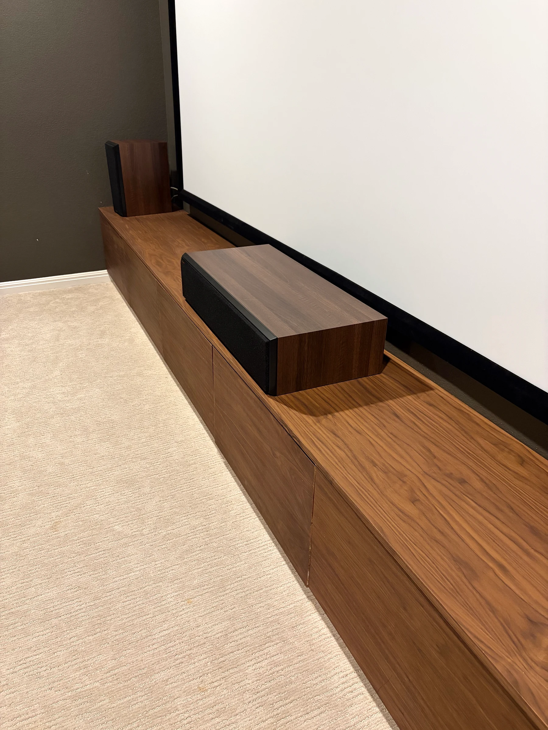 Angled detail showing the wood grain and flat fronts of the floating media cabinetry